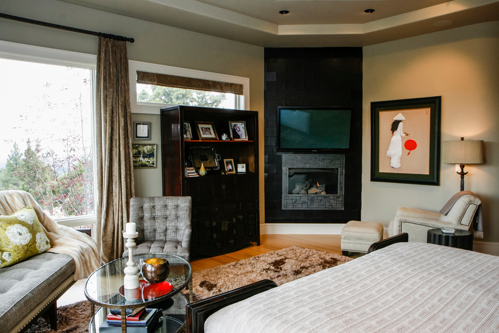 Large asian master bedroom in Other with beige walls, medium hardwood floors, a corner fireplace and a tile fireplace surround.