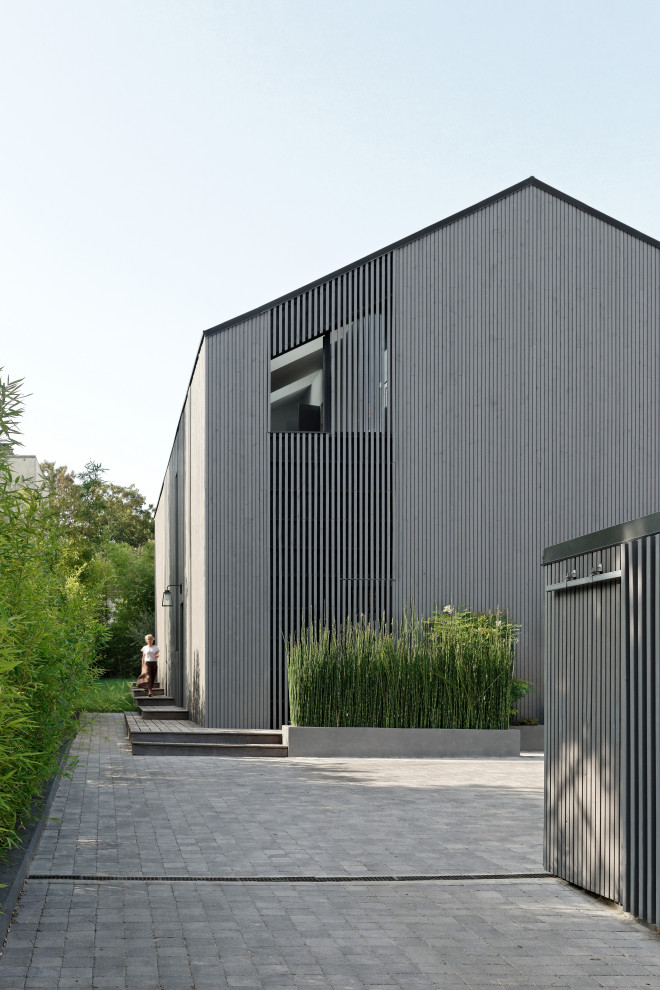 Exempel på ett stort modernt grått hus, med tre eller fler plan, sadeltak och tak i metall