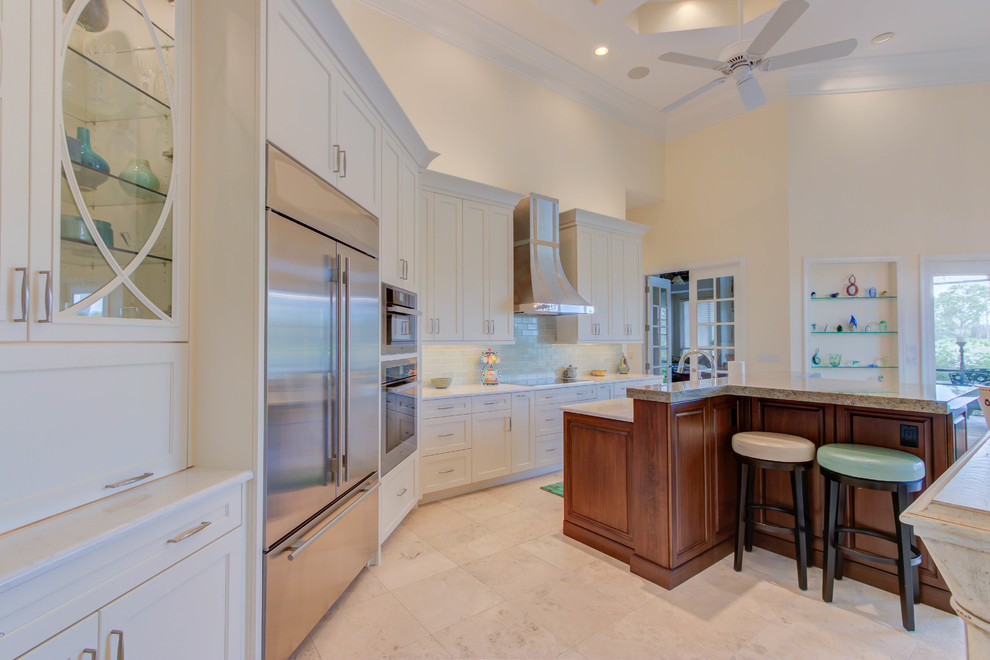 Example of a large transitional single-wall enclosed kitchen design with an undermount sink, flat-panel cabinets, white cabinets, quartz countertops, blue backsplash, stone tile backsplash, stainless steel appliances and an island