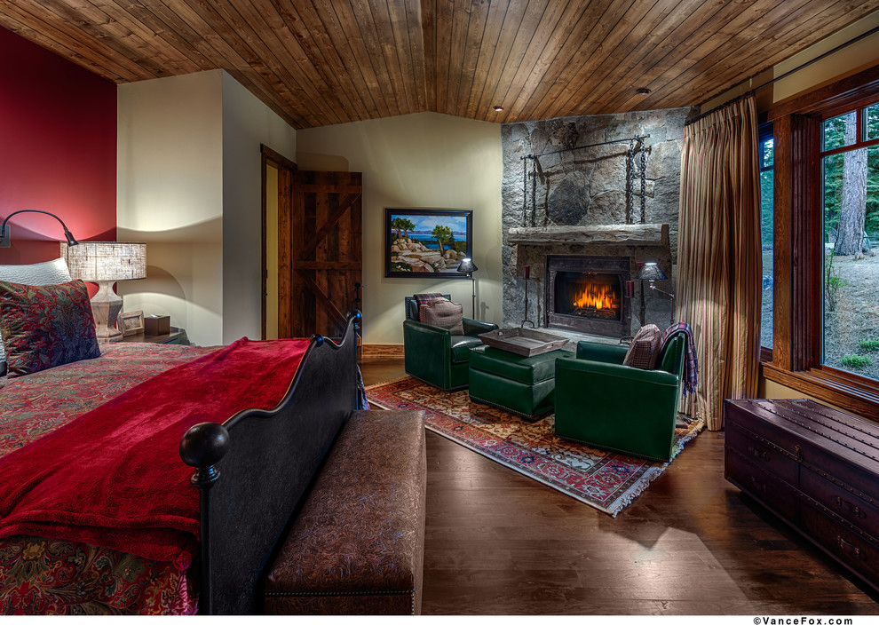Photo of a country bedroom in Sacramento with a stone fireplace surround.
