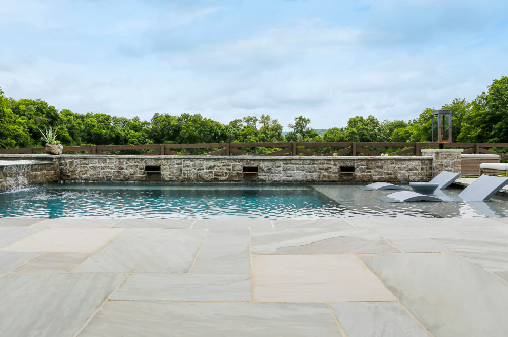Foto de piscina de estilo de casa de campo de tamaño medio rectangular en patio trasero con privacidad y adoquines de piedra natural