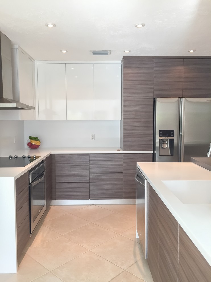 This is an example of a mid-sized modern l-shaped open plan kitchen in Miami with solid surface benchtops, an integrated sink, flat-panel cabinets, medium wood cabinets, white splashback, stone slab splashback, stainless steel appliances, ceramic floors, with island, beige floor and grey benchtop.