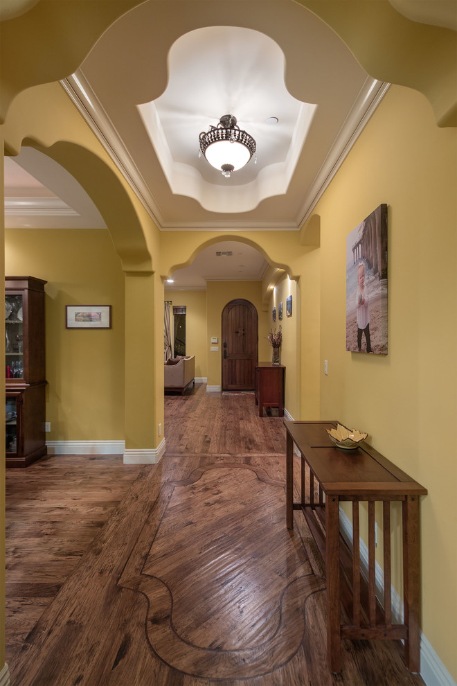 Inspiration for a small mediterranean hallway in Los Angeles with yellow walls and medium hardwood floors.