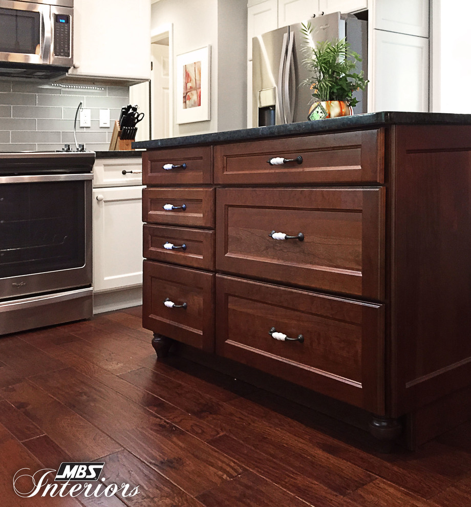 Inspiration for a mid-sized transitional l-shaped medium tone wood floor and brown floor eat-in kitchen remodel with an undermount sink, white cabinets, granite countertops, gray backsplash, subway tile backsplash, stainless steel appliances, an island and recessed-panel cabinets