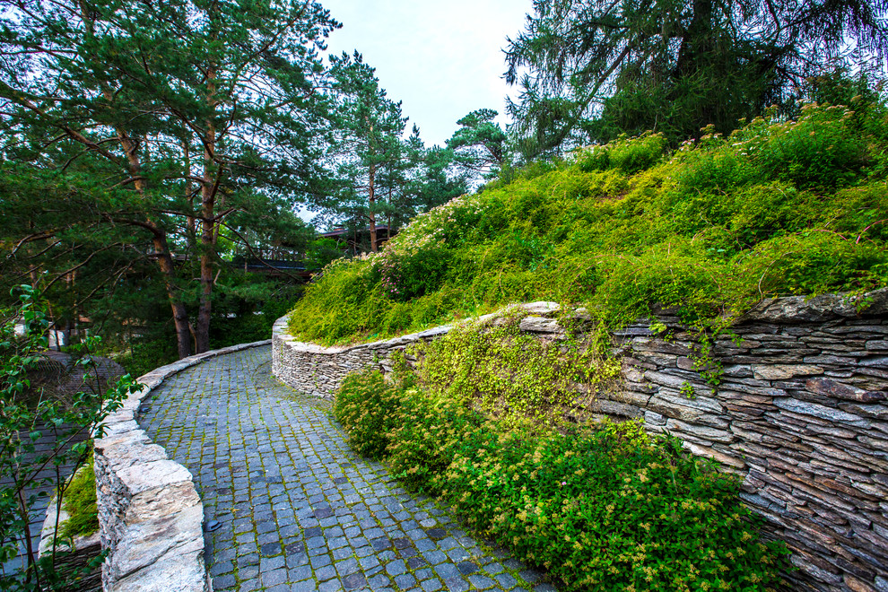 Photo of a scandinavian garden in Moscow with a retaining wall.