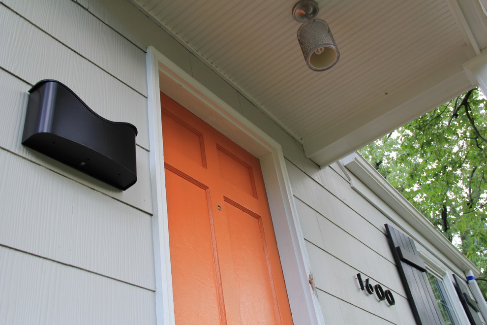 Photo of a mid-sized modern front door in Richmond with grey walls, concrete floors, a single front door and an orange front door.