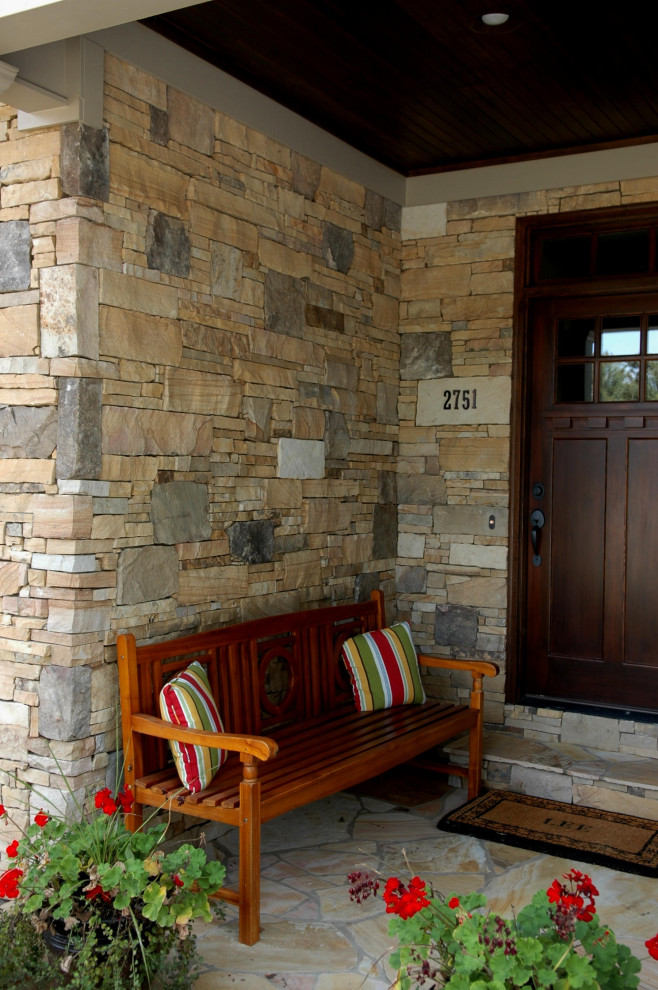 Idée de décoration pour un petit porche d'entrée de maison avant tradition avec des pavés en pierre naturelle et une extension de toiture.