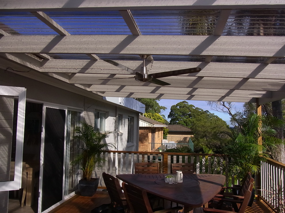 Mid-sized beach style courtyard patio in Sydney with a pergola.