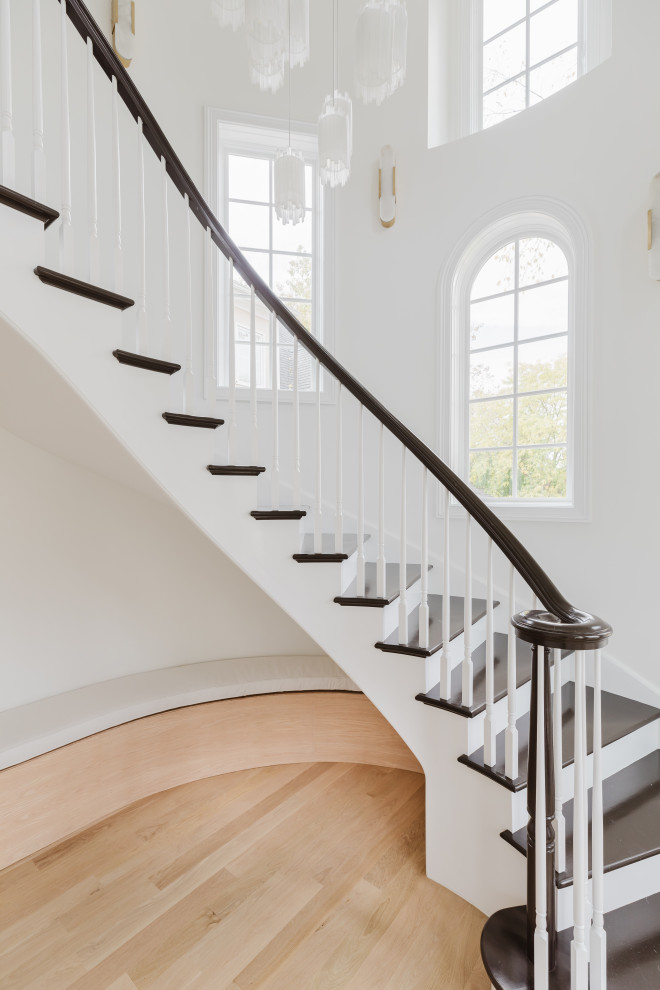 Elegant Home Interior Entrance With Curved Staircase and Black Double Doors