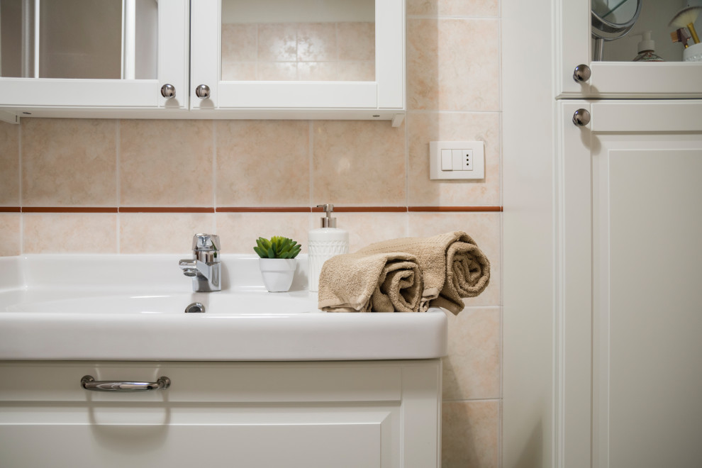 Modern inredning av ett litet vit vitt badrum med dusch, med luckor med glaspanel, vita skåp, en toalettstol med separat cisternkåpa, rosa kakel, porslinskakel, vita väggar, klinkergolv i porslin, ett nedsänkt handfat, bänkskiva i kvarts, grönt golv och dusch med skjutdörr