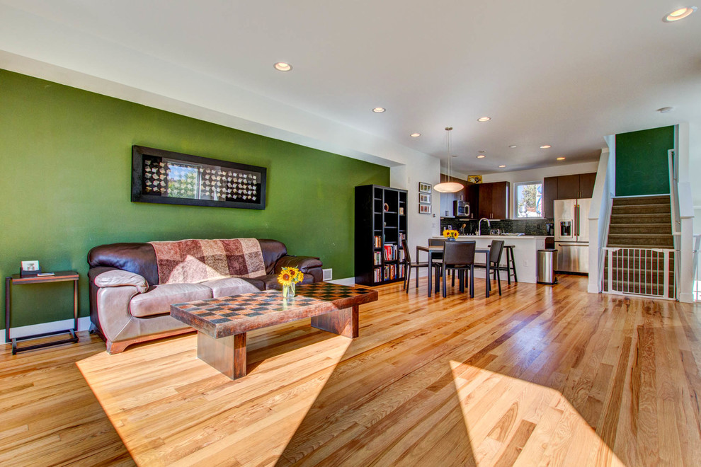 Inspiration for a modern open concept living room in Denver with a music area, green walls and light hardwood floors.