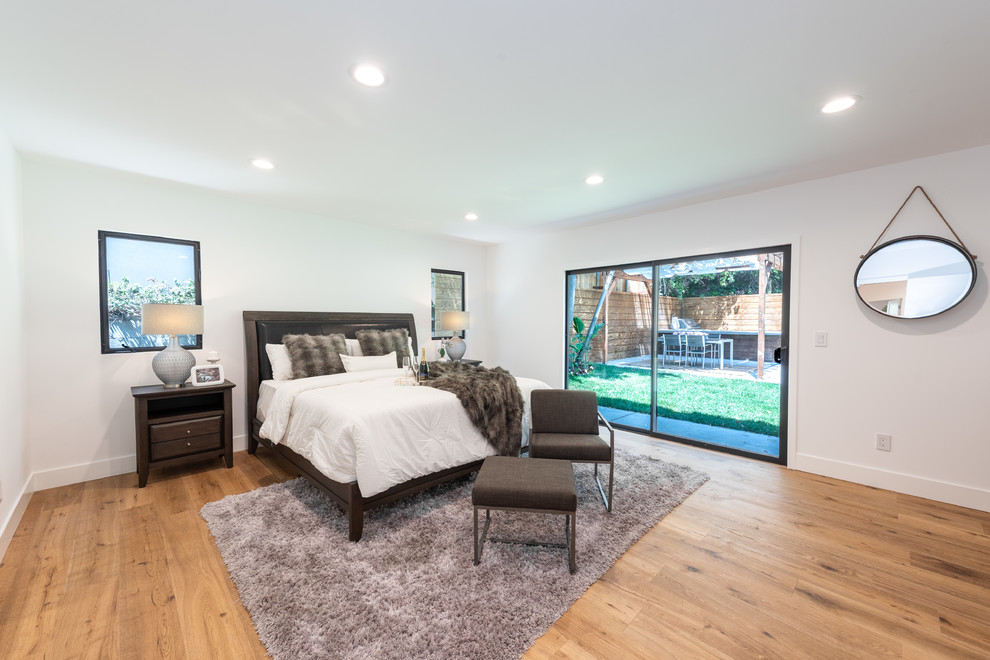 Design ideas for a mid-sized contemporary master bedroom in Los Angeles with white walls, medium hardwood floors, no fireplace and brown floor.