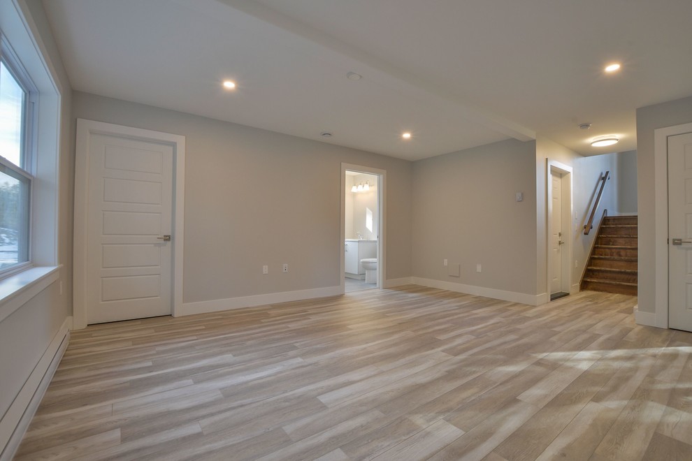 Example of a mid-sized transitional walk-out beige floor basement design with gray walls