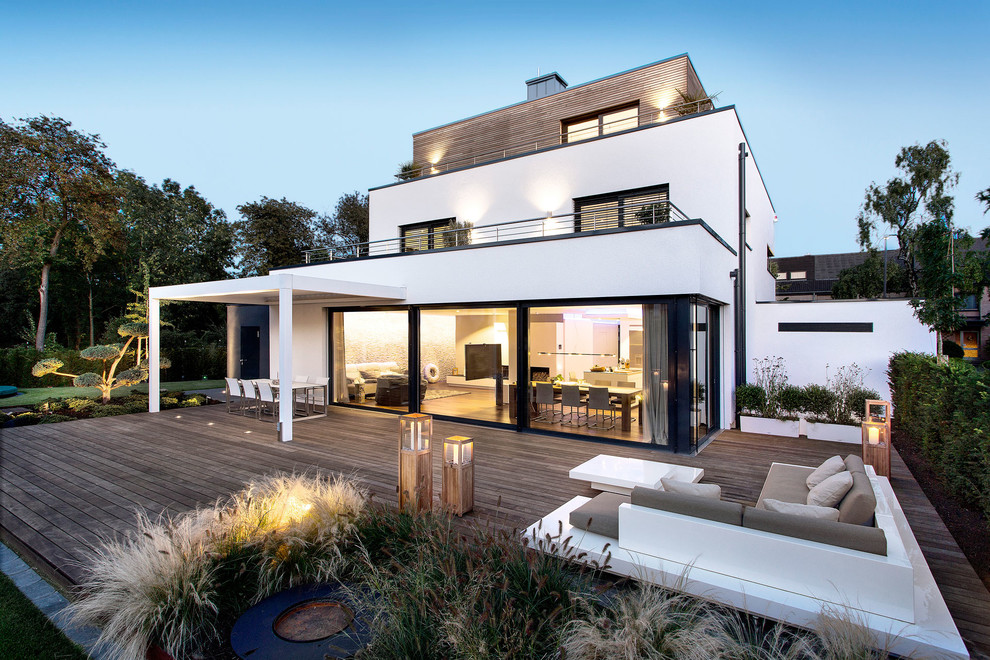 Design ideas for a large contemporary three-storey white house exterior in Bremen with mixed siding and a flat roof.