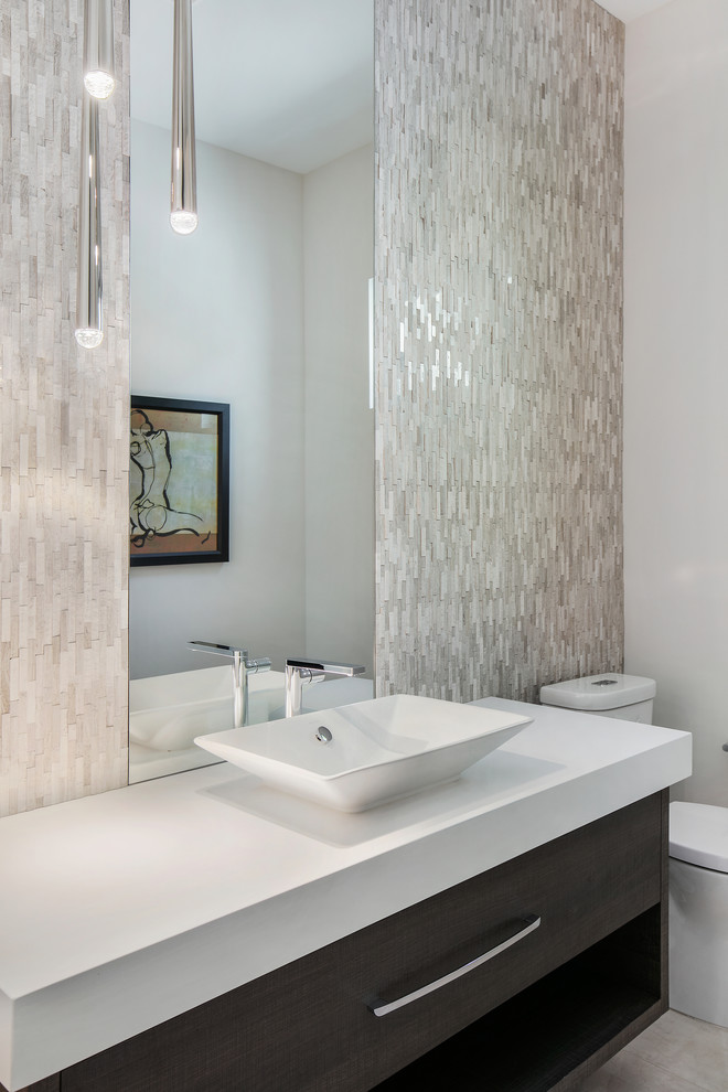 This is an example of a mid-sized modern powder room in Tampa with flat-panel cabinets, dark wood cabinets, a two-piece toilet, white tile, mosaic tile, white walls, porcelain floors, a vessel sink, engineered quartz benchtops, white floor and white benchtops.