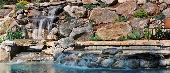Design ideas for a mid-sized modern backyard custom-shaped pool in New York with a water feature and stamped concrete.