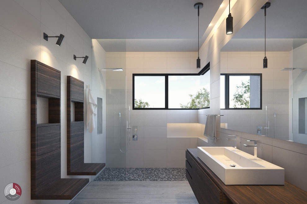 This is an example of a large asian master bathroom in Los Angeles with flat-panel cabinets, medium wood cabinets, an open shower, a one-piece toilet, white tile, pebble tile, white walls, porcelain floors, a pedestal sink and wood benchtops.