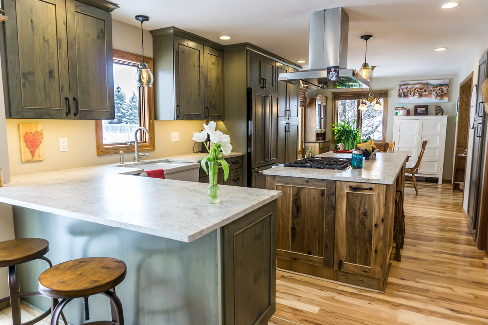 Open concept kitchen - large rustic light wood floor and brown floor open concept kitchen idea with beaded inset cabinets, distressed cabinets, granite countertops, an island and white countertops