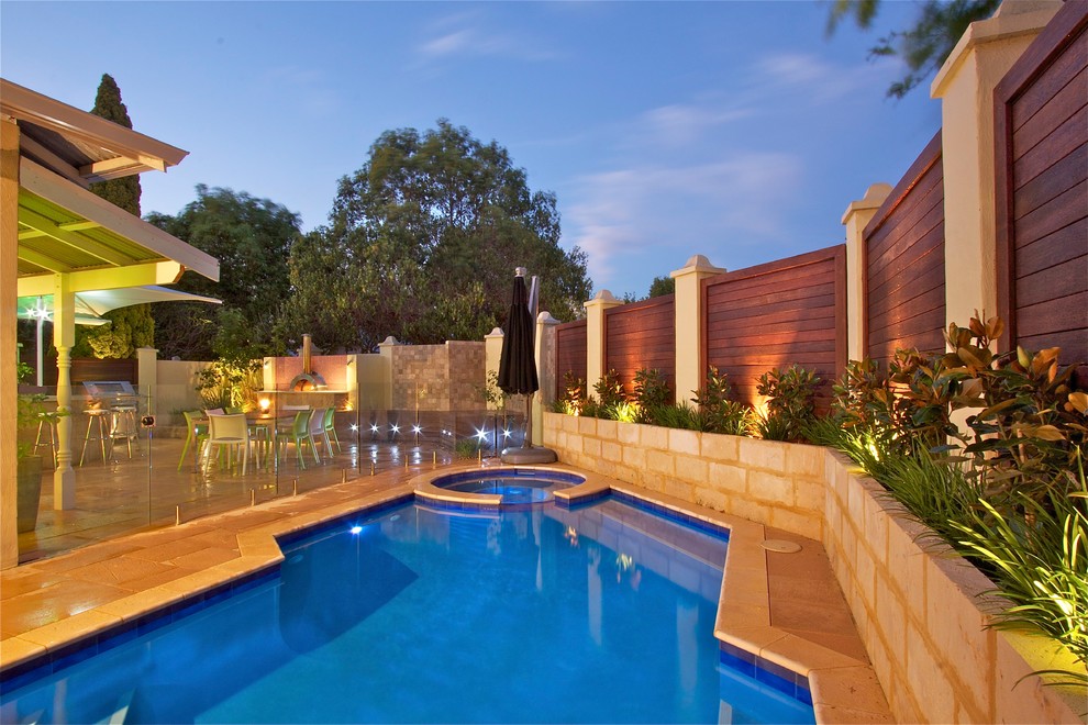 Contemporary backyard custom-shaped pool in Perth with natural stone pavers and a hot tub.