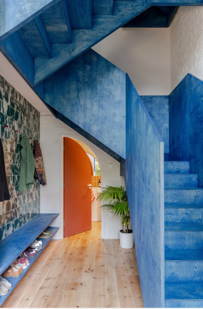 Photo of a large contemporary painted wood l-shaped wood railing staircase in London with painted wood risers.
