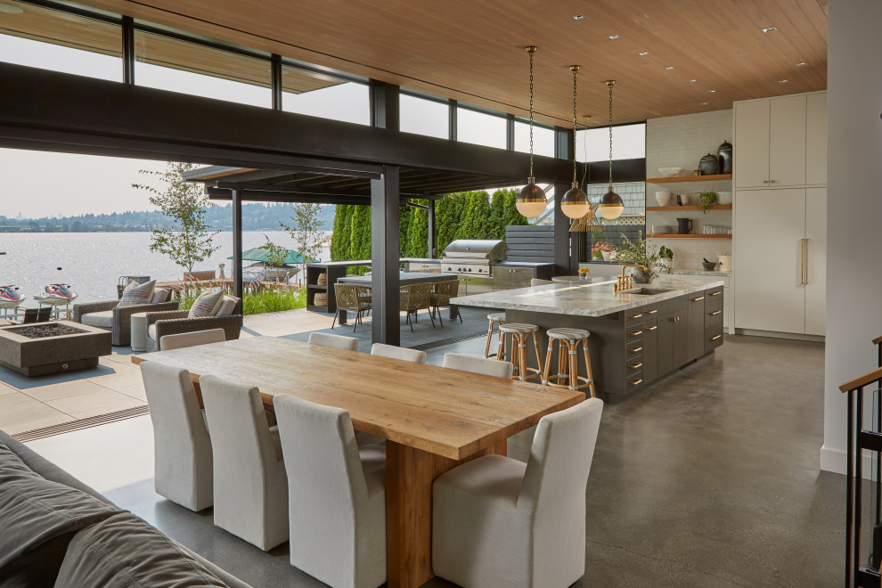Réalisation d'une salle à manger minimaliste avec sol en béton ciré et un plafond en bois.