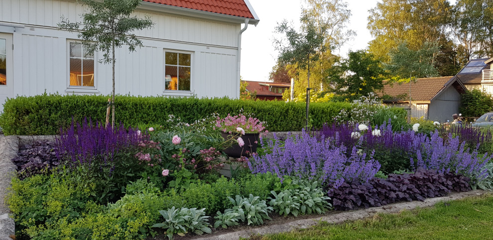 Idée de décoration pour un petit jardin avant tradition l'été avec un massif de fleurs et une exposition ensoleillée.