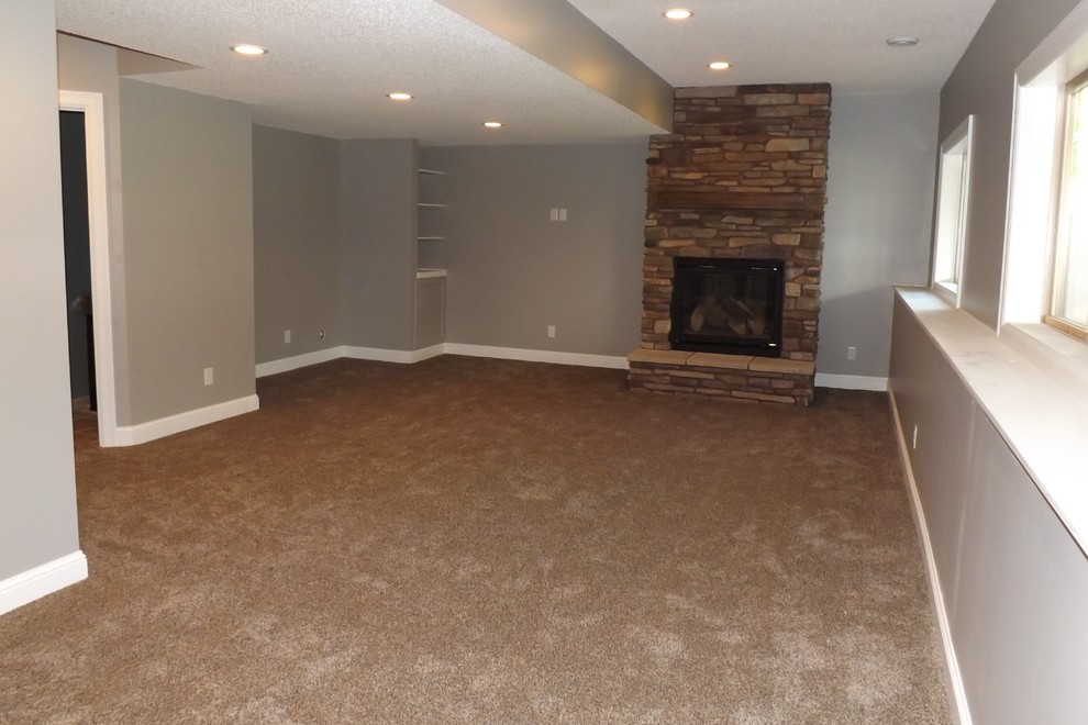 Design ideas for a large traditional look-out basement in Minneapolis with grey walls, carpet and a standard fireplace.
