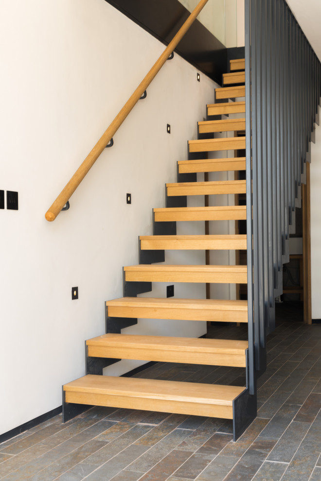 Photo of a medium sized contemporary wood floating metal railing staircase in Cornwall with open risers.