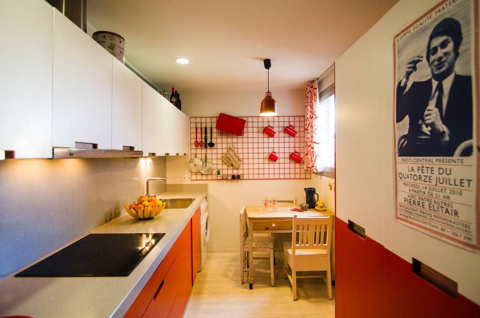 Photo of a mid-sized eclectic single-wall separate kitchen in Madrid with a single-bowl sink, flat-panel cabinets, red cabinets, grey splashback and no island.