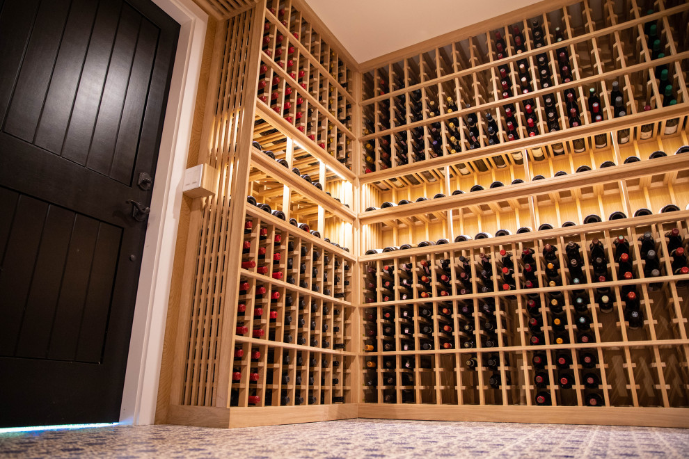 Photo of a mid-sized country wine cellar in Orange County with porcelain floors, storage racks and blue floor.