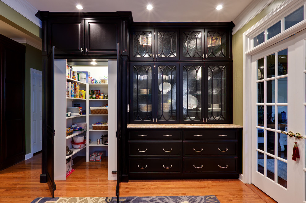 Inspiration for a large traditional kitchen pantry in Atlanta with raised-panel cabinets, black cabinets, granite benchtops, medium hardwood floors, brown floor and beige benchtop.