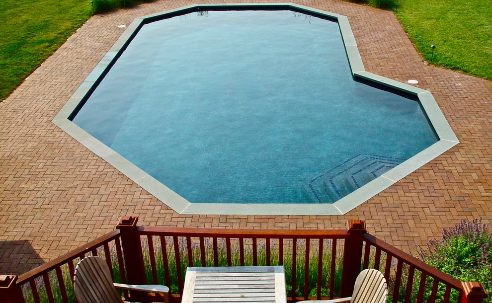 Design ideas for a mid-sized traditional side yard custom-shaped pool in New York with brick pavers.
