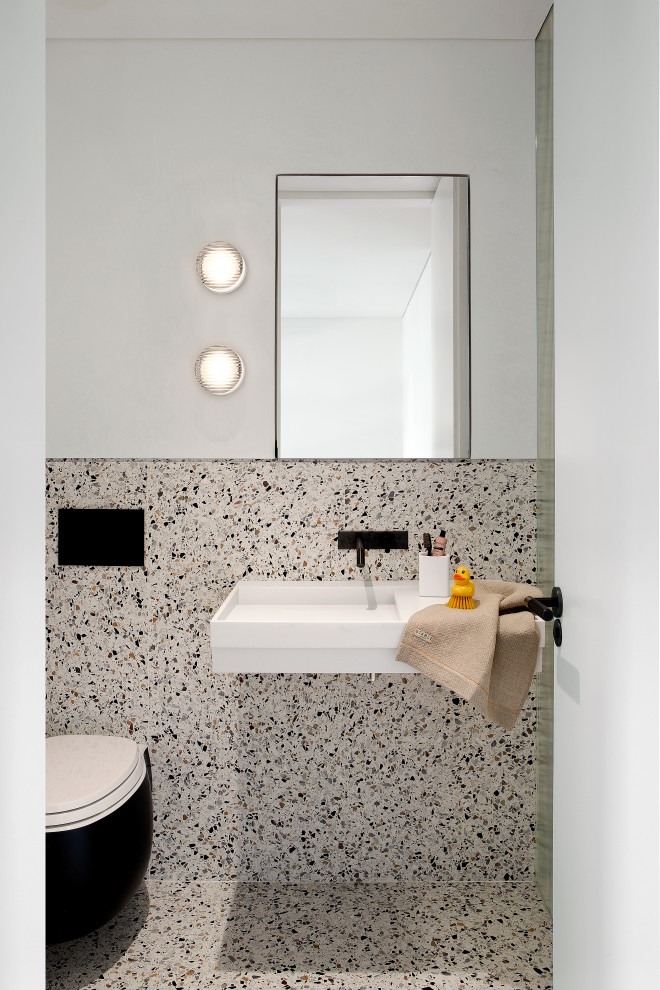 Exempel på ett modernt toalett, med grå väggar, ett väggmonterat handfat och grått golv