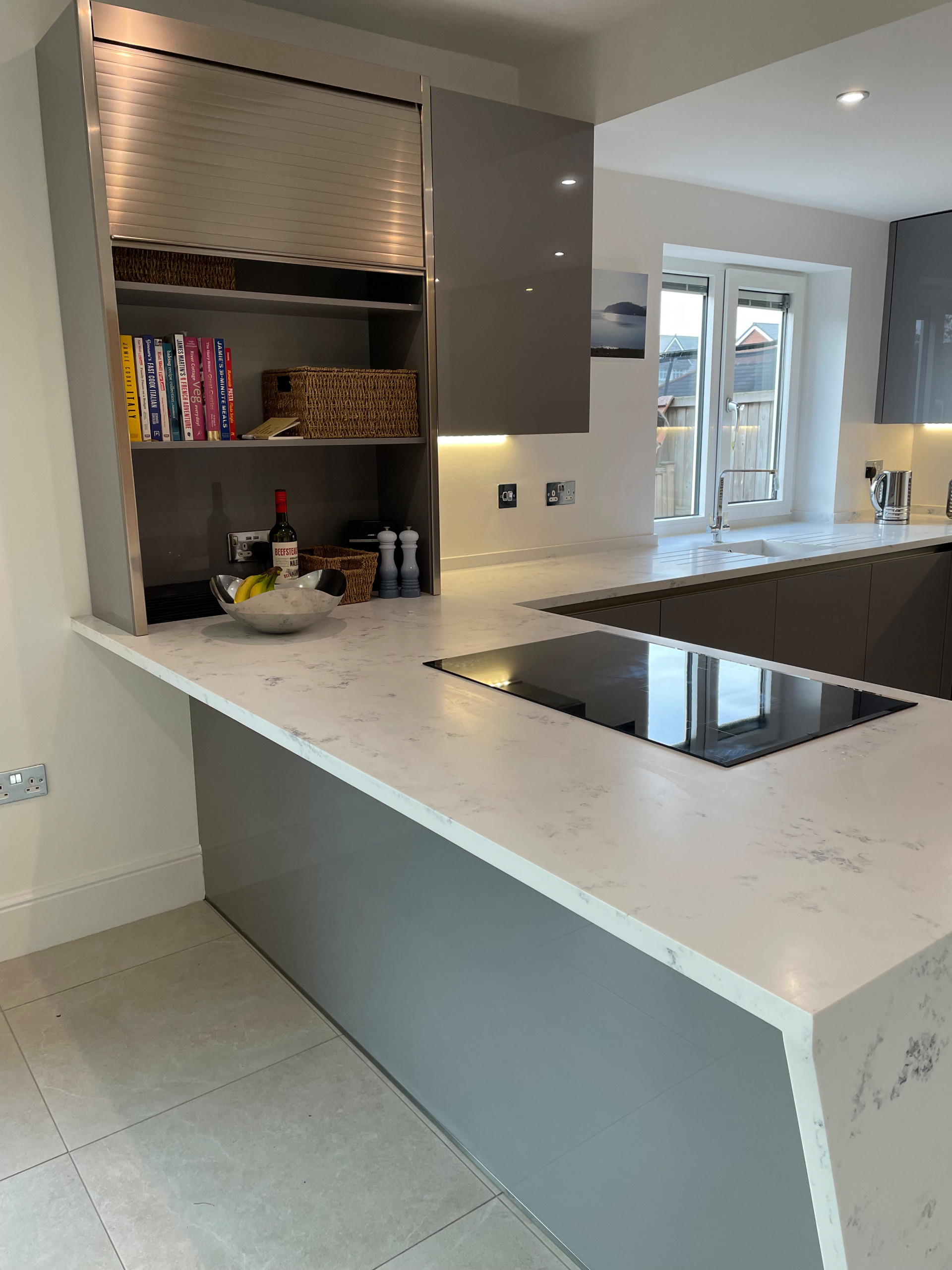 High Gloss Gravel Handleless Kitchen with White and Grey Solid Surface Tops