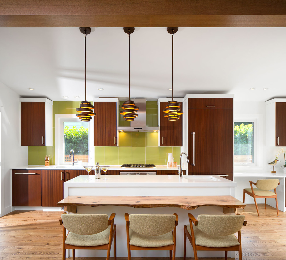 This is an example of a midcentury single-wall open plan kitchen in Vancouver with an undermount sink, brown cabinets, quartz benchtops, green splashback, terra-cotta splashback and panelled appliances.