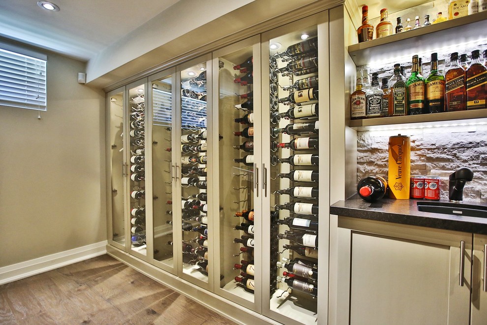 Design ideas for a large transitional wine cellar in Toronto with dark hardwood floors and display racks.