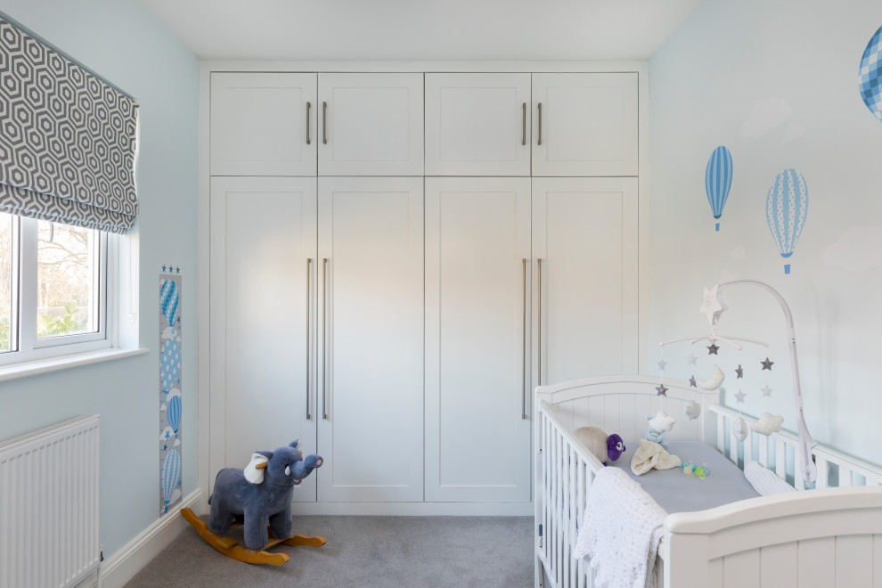 Design ideas for a mid-sized transitional nursery for boys in London with carpet and grey floor.