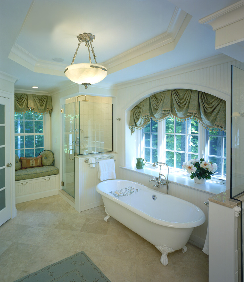 Photo of a large traditional master bathroom in DC Metro with white cabinets, a claw-foot tub, a corner shower, beige tile, stone tile, beige walls and travertine floors.
