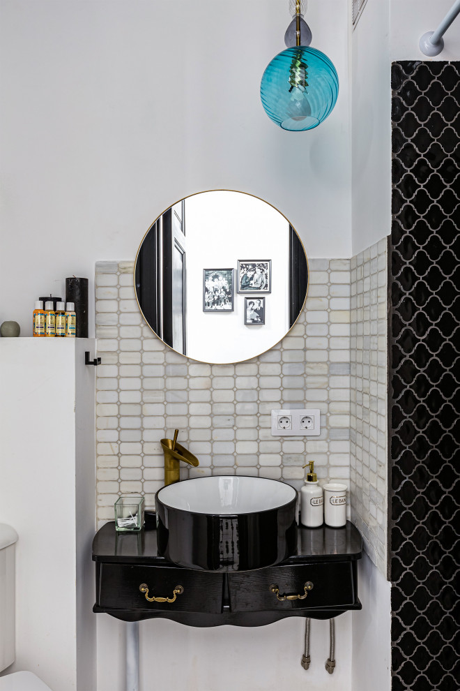 Inredning av ett 60 tals litet svart svart badrum med dusch, med svarta skåp, en dusch i en alkov, vit kakel, keramikplattor, ett fristående handfat och träbänkskiva