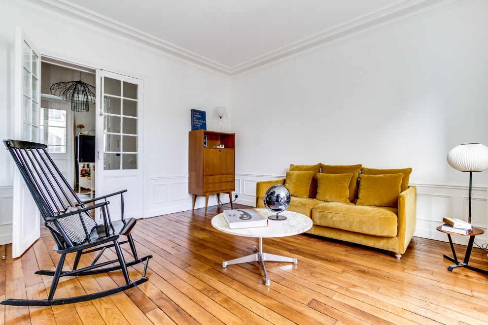 Foto di un piccolo soggiorno minimal aperto con libreria, pareti bianche, parquet chiaro, nessuna TV e pavimento beige