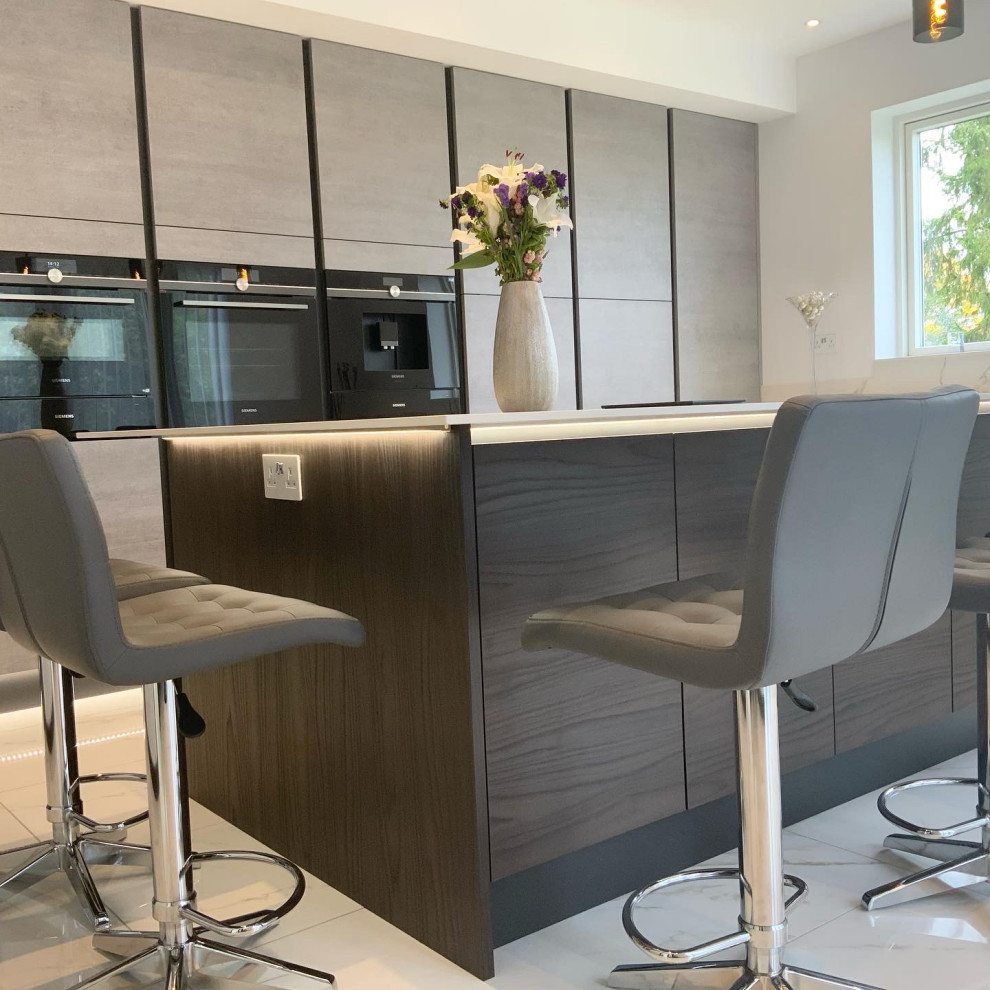 Photo of a large contemporary l-shaped kitchen in Buckinghamshire with flat-panel cabinets, grey cabinets, with island and white benchtop.