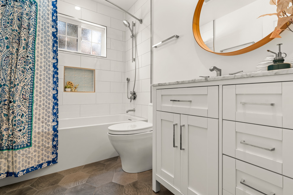 На фото: детская ванная комната среднего размера в морском стиле с фасадами в стиле шейкер, белыми фасадами, ванной в нише, душем над ванной, унитазом-моноблоком, белой плиткой, керамогранитной плиткой, белыми стенами, полом из керамической плитки, врезной раковиной, столешницей из искусственного камня, разноцветным полом, шторкой для ванной, белой столешницей, нишей, тумбой под одну раковину и напольной тумбой с