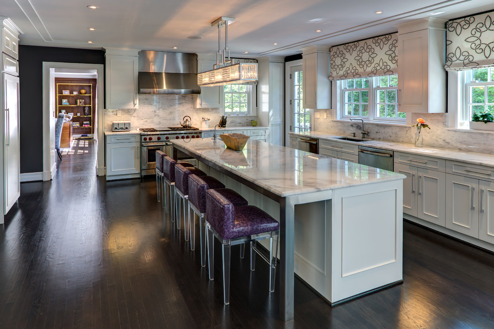 Design ideas for a large transitional l-shaped eat-in kitchen in DC Metro with an undermount sink, shaker cabinets, white cabinets, marble benchtops, white splashback, marble splashback, stainless steel appliances, dark hardwood floors, with island, brown floor and white benchtop.