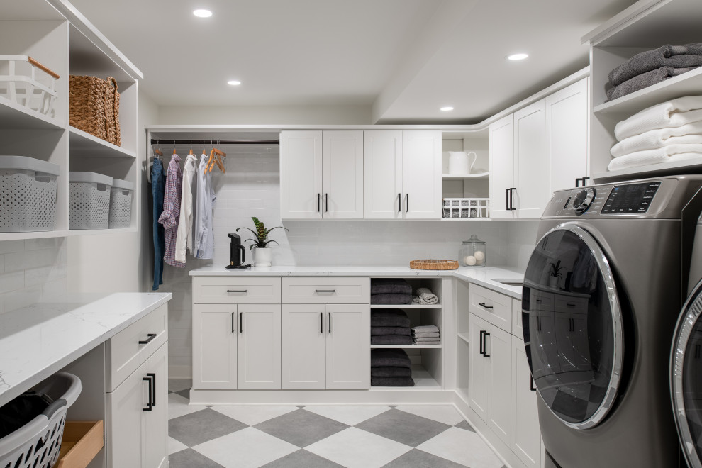 This is an example of a large transitional u-shaped dedicated laundry room in Burlington with an undermount sink, shaker cabinets, white cabinets, quartzite benchtops, white splashback, cement tile splashback, white walls, porcelain floors, a side-by-side washer and dryer and white benchtop.