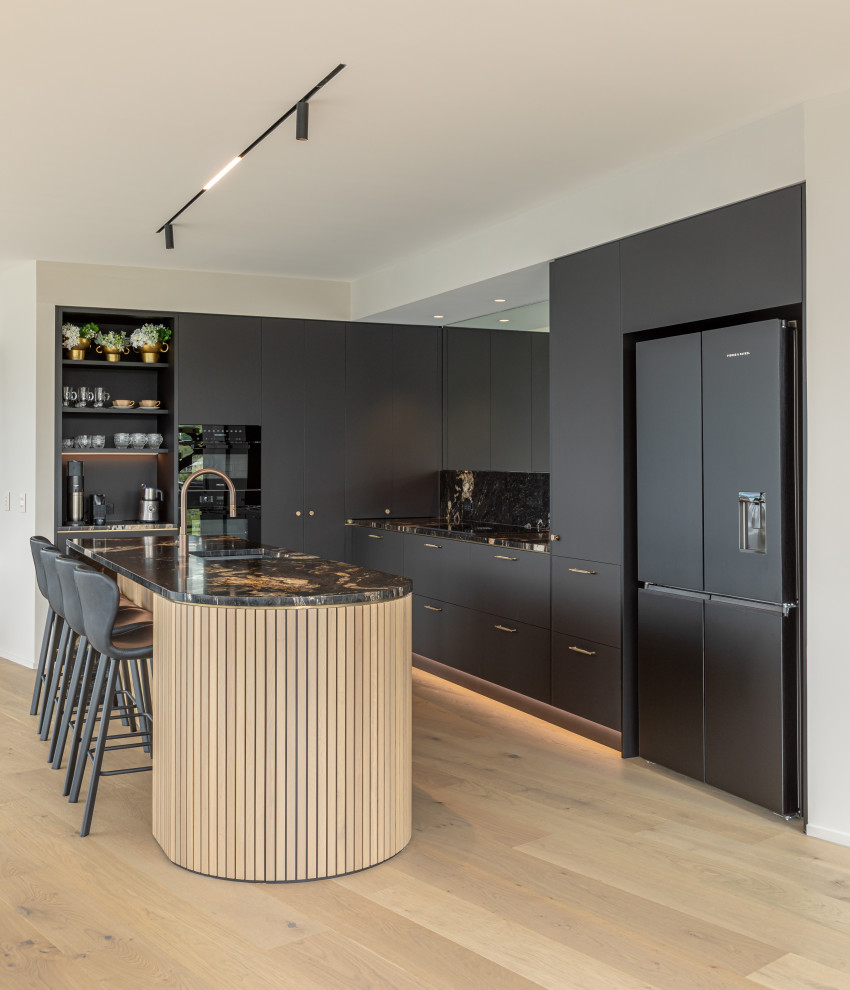 Foto på ett mellanstort funkis flerfärgad kök, med en undermonterad diskho, släta luckor, svarta skåp, bänkskiva i kvarts, flerfärgad stänkskydd, svarta vitvaror, mellanmörkt trägolv, en köksö och brunt golv