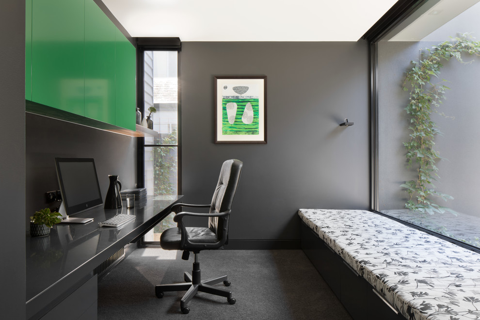 Mid-sized modern study room in Melbourne with black walls, carpet and a built-in desk.