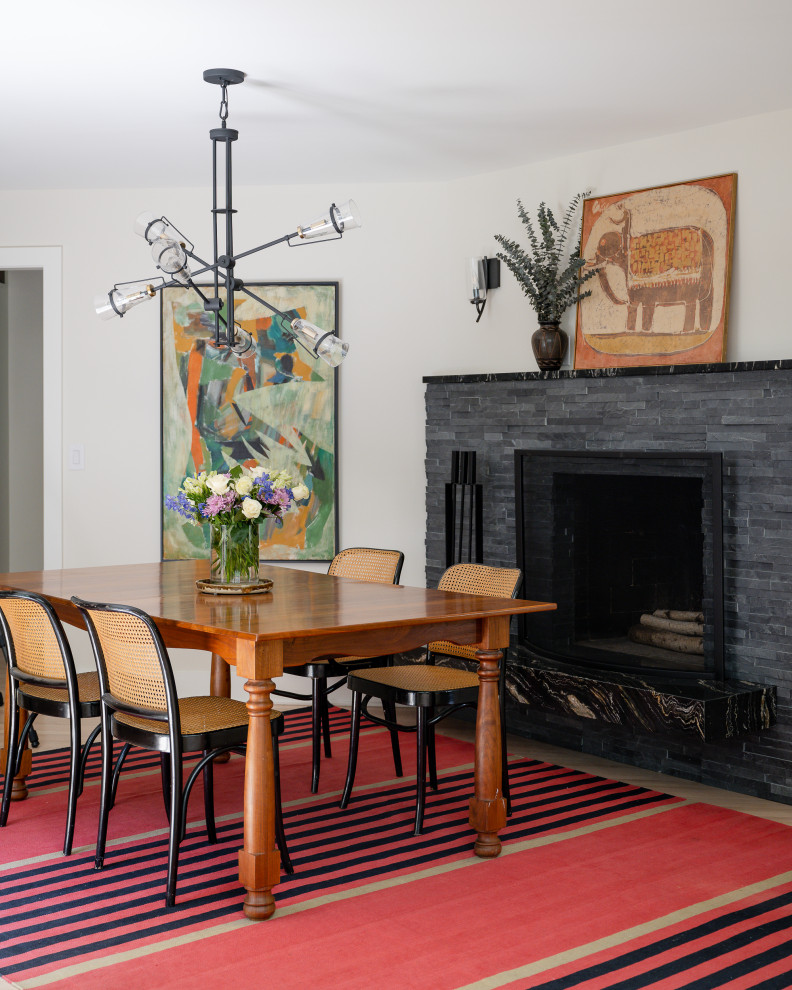 Aménagement d'une petite salle à manger classique fermée avec un mur blanc, un sol en bois brun et un manteau de cheminée en pierre de parement.