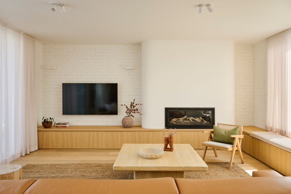 Inspiration for a mid-sized contemporary open concept living room in Geelong with white walls, light hardwood floors, a wall-mounted tv, brick walls, a ribbon fireplace and beige floor.