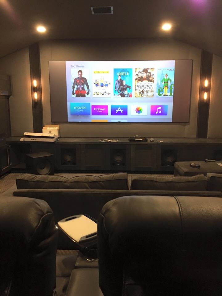 Photo of a large contemporary enclosed home theatre in Los Angeles with grey walls, carpet and a wall-mounted tv.