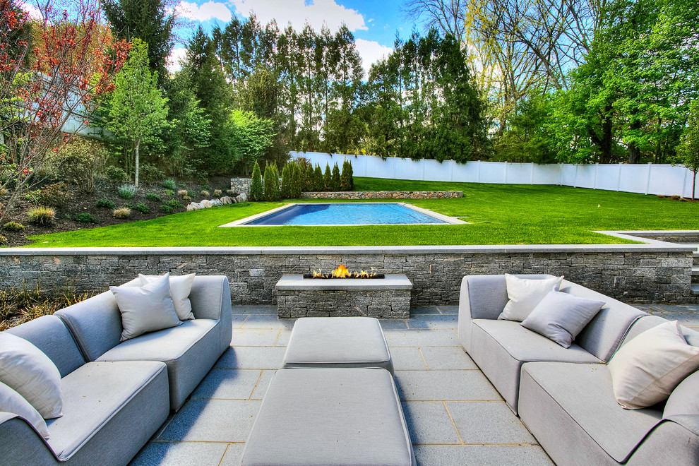Design ideas for a transitional backyard patio in New York with a fire feature, concrete pavers and no cover.